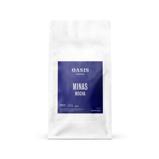A sealed pouch packaging of OASIS Minas Mocha coffee in white color with a blue label.