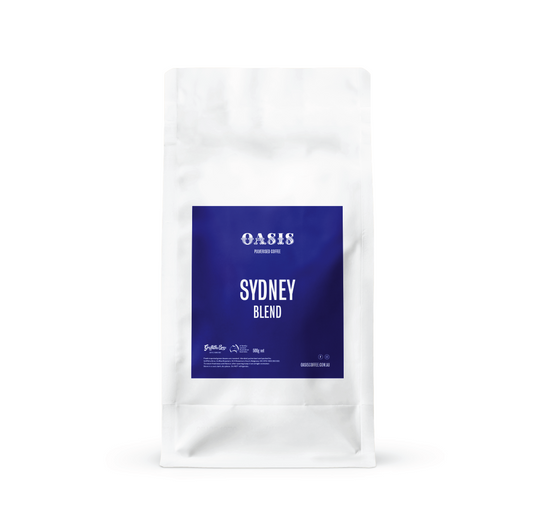 White coffee bag with blue label featuring 'Oasis' and 'Sydney Blend' on a white background